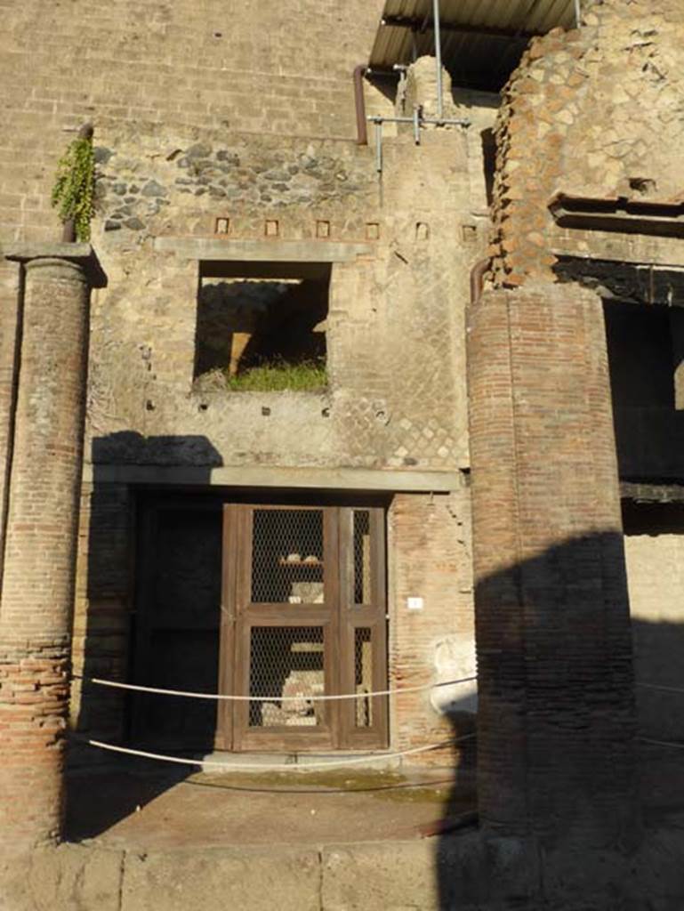 Decumanus Maximus, Herculaneum, September 2015. Buildings on north side of the Decumanus Maximus, doorway number 1. This shows a modern door that closes shop no. 1.  Inside one could see the objects exhibited by Maiuri, after their excavation.
See Camardo, D, and Notomista, M, eds. (2017). Ercolano: 1927-1961. L’impresa archeologico di Amedeo Maiuri e l’esperimento della citta museo. Rome, L’Erma di Bretschneider, (p.278, Scheda 54)
