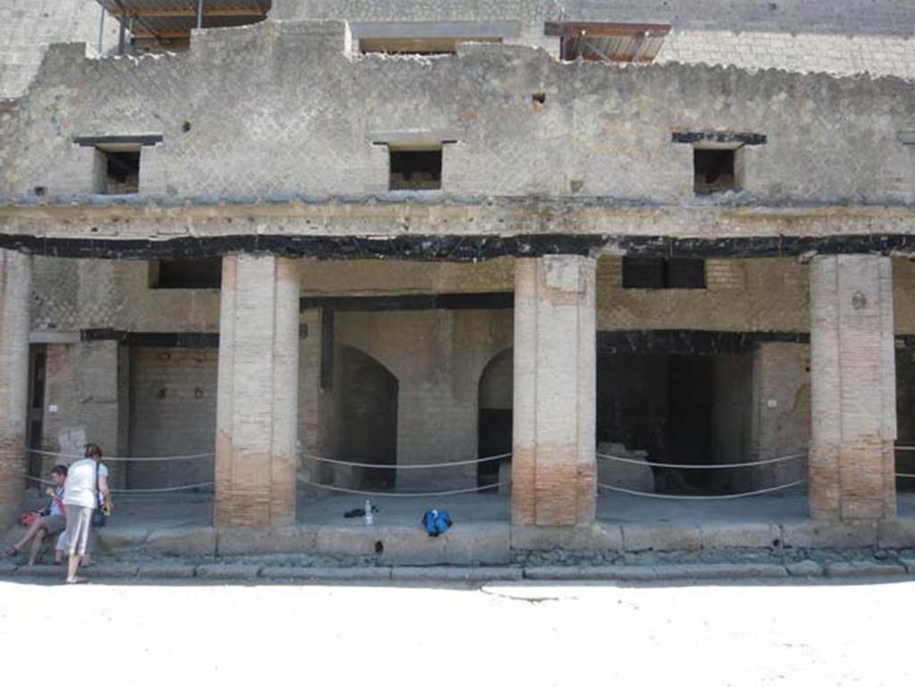 Decumanus Maximus, Herculaneum. August 2013. North side, with doorways set under portico, and windows above. Photo courtesy of Buzz Ferebee.
