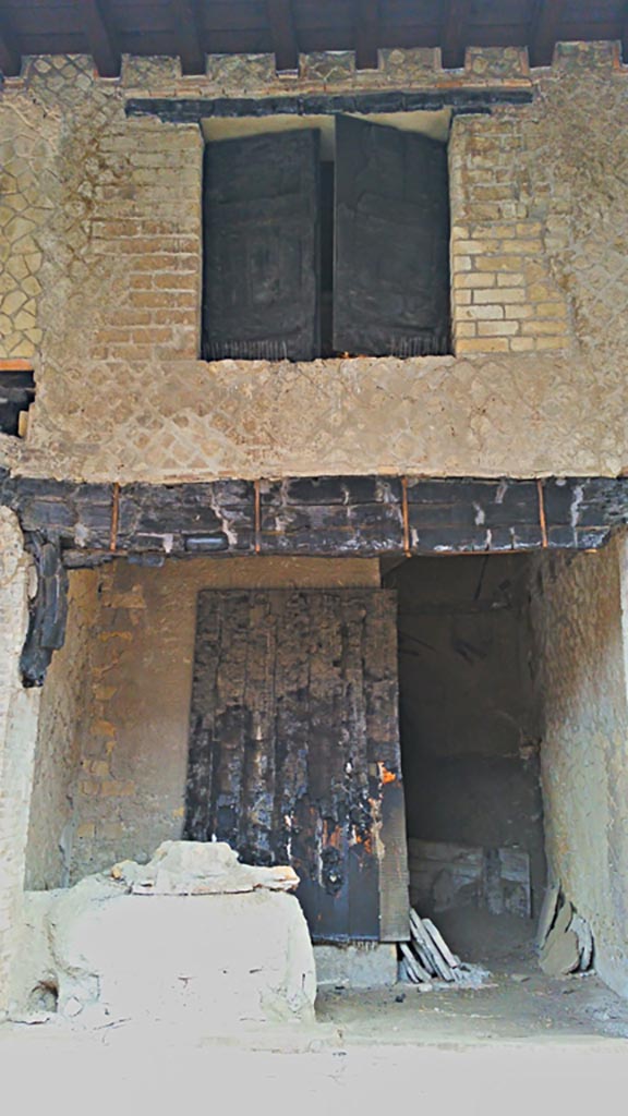 Decumanus Maximus, north side, Herculaneum, photo taken between October 2014 and November 2019.
Doorway number 4 with the remains of door and window shutters in carbonised wood. 
Photo courtesy of Giuseppe Ciaramella.
