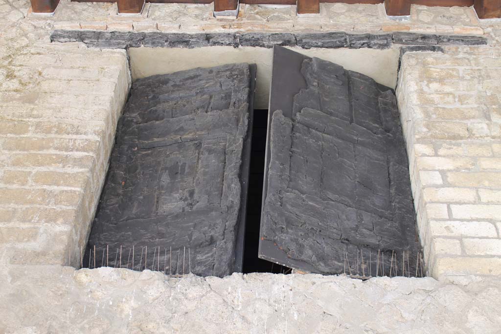 Decumanus Maximus, Herculaneum. March 2014. Detail of window shutters above doorway numbered 4.
Foto Annette Haug, ERC Grant 681269 DÉCOR.
