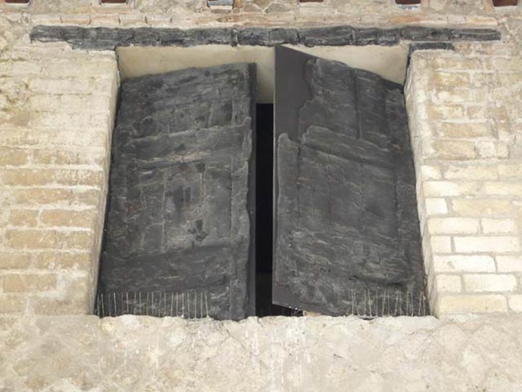 Decumanus Maximus, Herculaneum. August 2013. Detail of window above doorway numbered 6. Photo courtesy of Buzz Ferebee.
