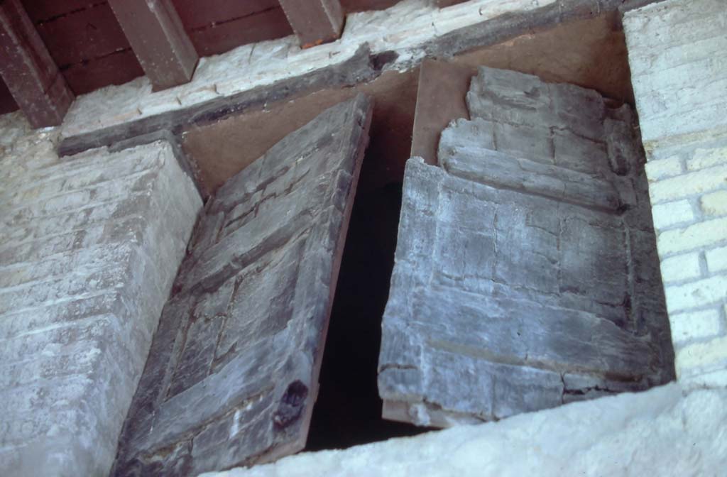 Decumanus Maximus, Herculaneum. 7th August 1976. Detail of window above doorway numbered 4.
Photo courtesy of Rick Bauer, from Dr George Fay’s slides collection.

