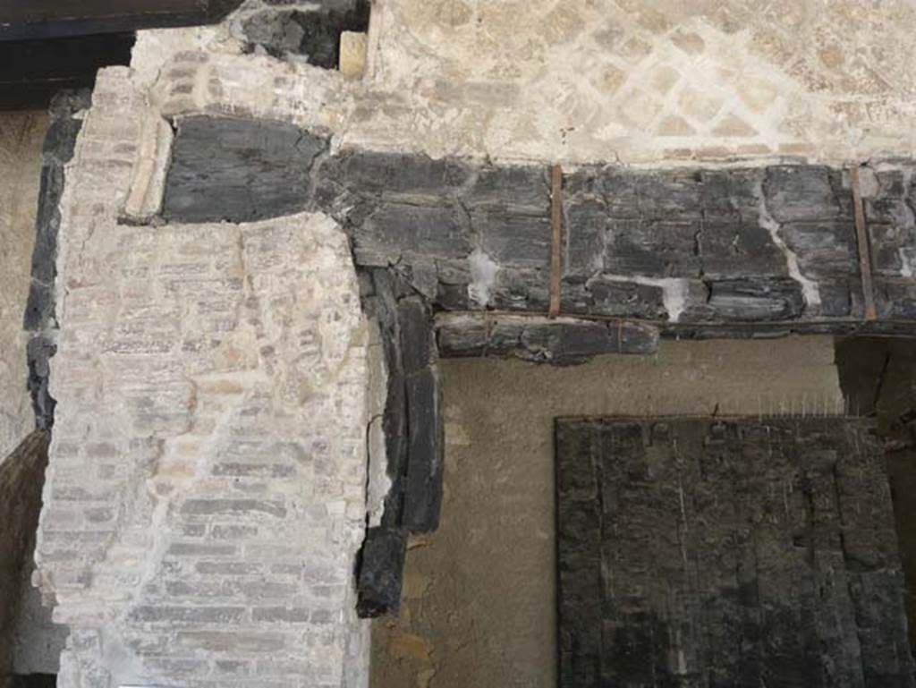 Decumanus Maximus, Herculaneum. August 2013. Detail of carbonised wood from above doorway numbered 6. Photo courtesy of Buzz Ferebee.
