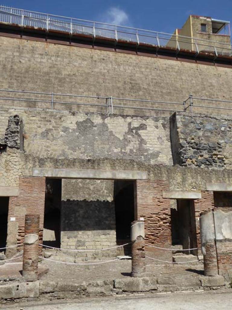 Decumanus Maximus, Herculaneum, July 2015. Building on north side of the Decumanus Maximus, doorway numbered 8, on left, and upper floor above.
Doorway with steps at number 9, is on the right. Photo courtesy of Michael Binns.
