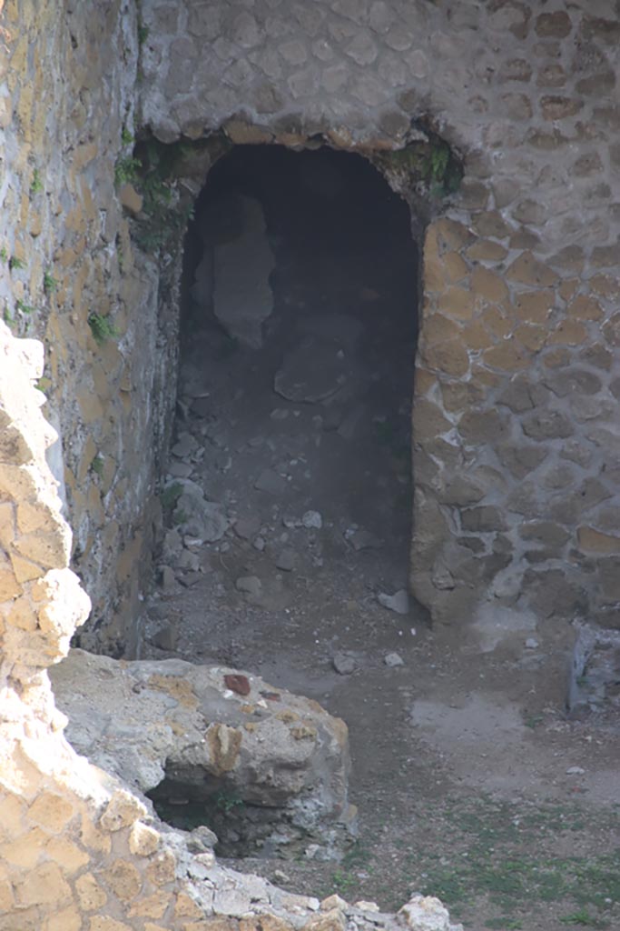 III.1/2/18/19, Herculaneum, October 2023. 
Doorway in north wall of room G, with remains of oven/hearth against west wall. 
Photo courtesy of Klaus Heese.

