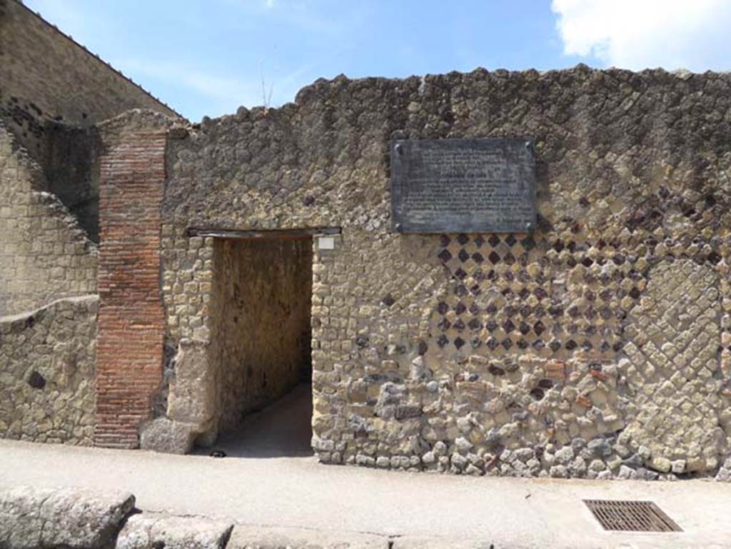 III.7 Herculaneum, July 2015. Looking south to entrance doorway to ancient public latrine.
The plaque records Amedeo Maiuri started the Nuovi Scavi di Ercolano here, at the extremity of the Bourbon excavations, on the 18th May 1927.
Photo courtesy of Michael Binns.
