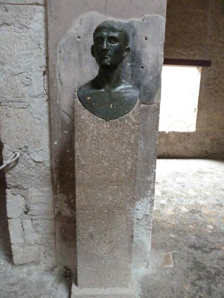 III 16, Herculaneum, September 2015. Reproduction bronze herm from which the house was named, perhaps the homeowner, on west side of atrium 9, near the tablinum.
According to Pesando and Guidobaldi, this herm was found in a room on the upper floor above room 3, the room on the north of the entrance doorway.
See Pesando, F. and Guidobaldi, M.P. (2006). Pompei, Oplontis, Ercolano, Stabiae. Editori Laterza, (p.327)

