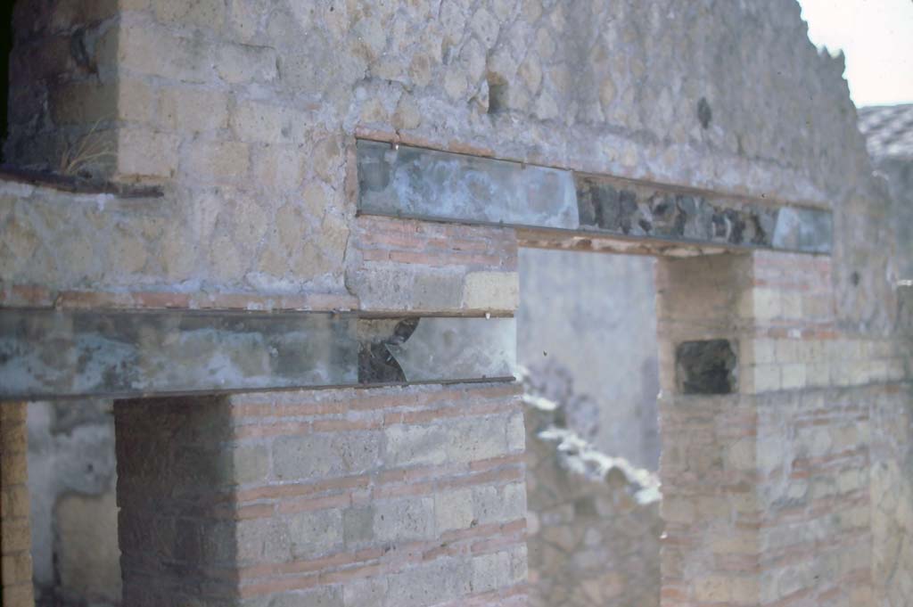 IV.4 Herculaneum. 7th August 1976. Carbonised wood above windows and doorways, on east side of Open Courtyard 6.
Photo courtesy of Rick Bauer, from Dr George Fay’s slides collection.

