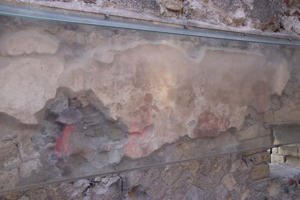 IV.17, Herculaneum, September 2019. 
Looking towards south wall with remains of the painted Priapus figure in centre, behind the sales counter.
A second painted figure is also still visible towards the right of the wall.  Photo courtesy of Klaus Heese.


