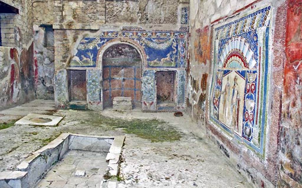 V.7, Herculaneum. October 2001. 
Looking towards north wall, north-east corner and east wall, on right, of internal courtyard.
Photo courtesy of Peter Woods.
Behind the triclinium was a richly decorated fountain, which hid the water reservoir of the fountain in the centre of the triclinium.
In the middle of the Nymphaeum, while the central niche received perhaps a purely decorative statuette, it was not used as fountain mouth, since it lacked the necessary basin in front and there was no trace of the passage of a lead pipe from behind tank/reservoir through the niche.

