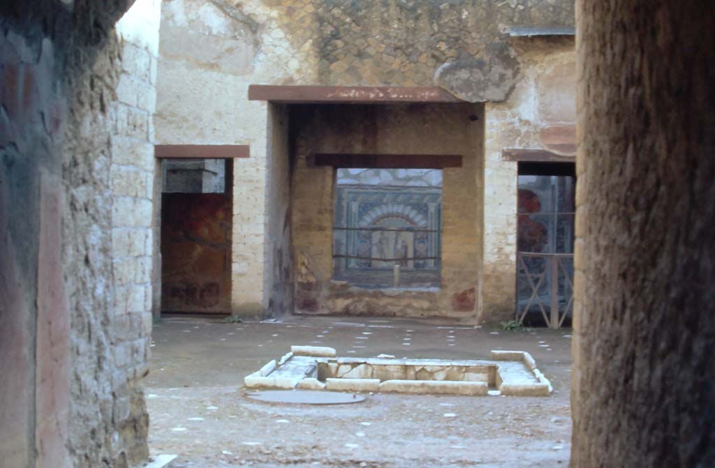 V.7 Herculaneum. 4th December 1971. Looking east across atrium towards tablinum, from entrance corridor.
Photo courtesy of Rick Bauer, from Dr George Fay’s slides collection.
