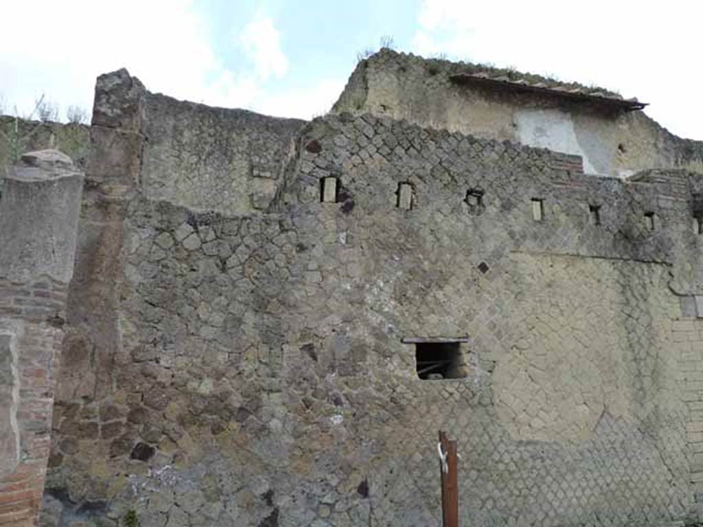 V.11, on left, Herculaneum. May 2010. Exterior west wall of houses on east side of Cardo IV. 
On the right is the kitchen window, under the holes for support beams of an upper floor, in V.8.

