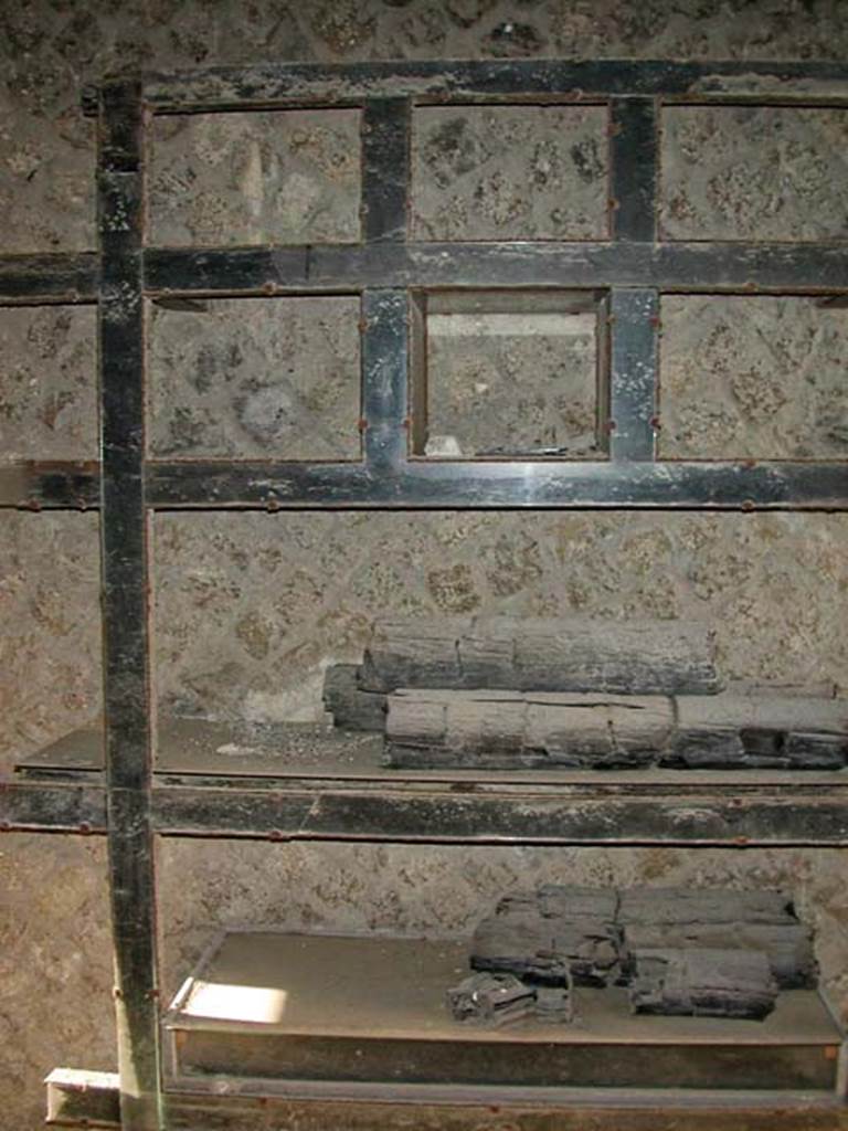 V.12 Herculaneum, September 2003. West wall of shop with cupboard/shelves of carbonized wood.
Photo courtesy of Nicolas Monteix.
