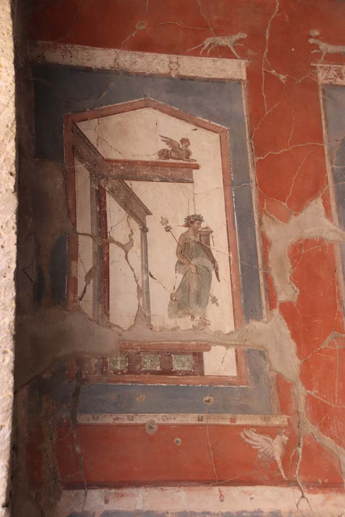 VI.16 Herculaneum. September 2021. 
Upper painting at north end of east wall showing a statue of a maenad holding a cornucopia. 
Photo courtesy of Klaus Heese.
