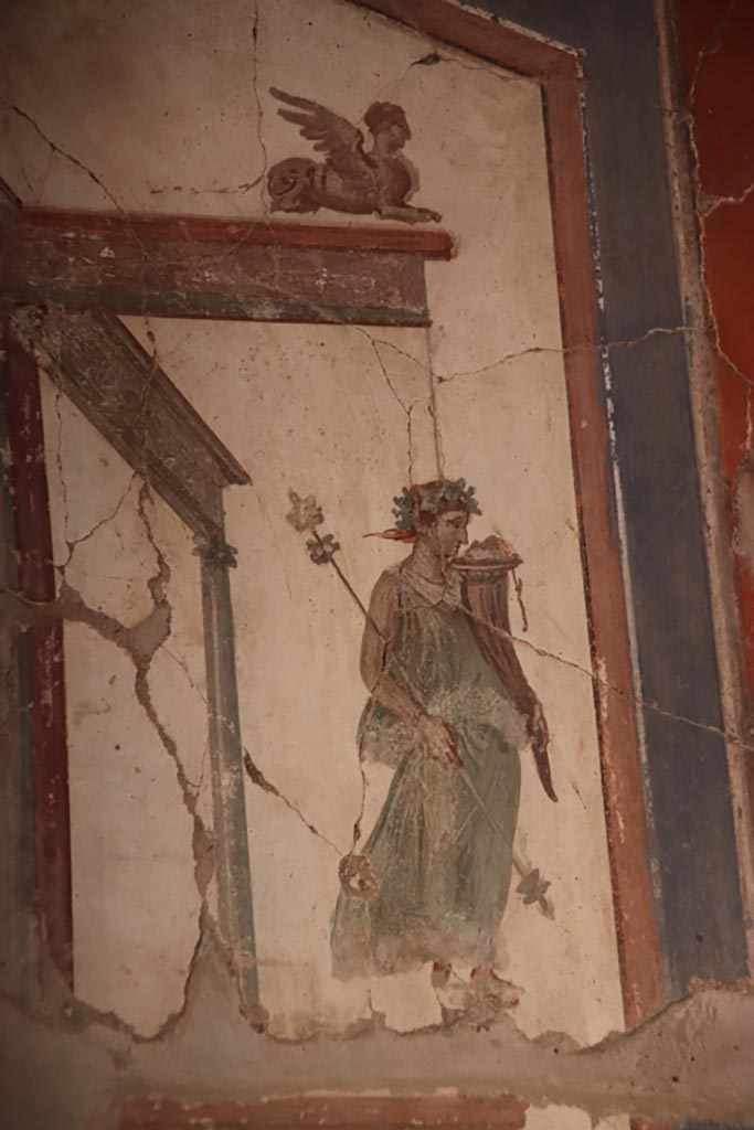 VI.16 Herculaneum. October 2022. 
Detail of painted maenad holding a cornucopia, from upper north end of east wall.  
Photo courtesy of Klaus Heese.
