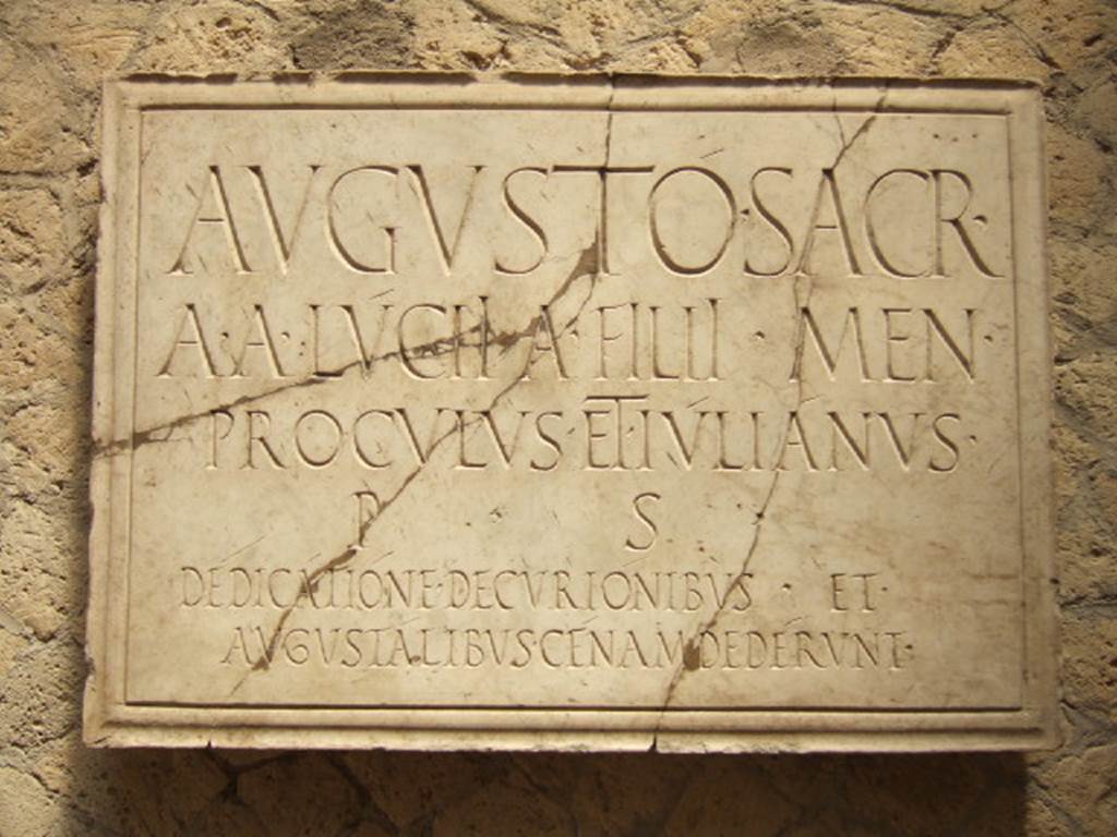 VI.21, Herculaneum. May 2006. Plaque on north wall. 
Deiss wrote that the identification of the Augustales’ structure in Herculaneum is made precise by the dedicatory inscription on the wall. 
The inscription fortunately was overlooked by the tunnellers, who stripped all the statuary (probably including Proculus and Julian) and the floors from this hall.
See Deiss, J.J. 1968. Herculaneum: a city returns to the sun. UK, The History Book Club, (p.154)

The inscription reads
AVGVSTO SACR
A A LUCII A FILII MEN
PROCVLVS ET IVLIANVS
P S
DEDICATIONE DECVRIONIBVS ET
AVGVSTALIBVS CENAM DEDERVNT.

According to Wallace-Hadrill this translates as –
“Sacred to Augustus. Aulus and Aulus Lucius, sons of Aulus, of the tribe Menenia, called Proculus and Julianus, at their own expense, to mark the dedication gave a dinner to the decuriones and the augustales.”
The plaque was found in 1961, according to the archival photograph on page 180.
See Wallace-Hadrill, A. (2011). Herculaneum, Past and Future. London, Frances Lincoln Ltd., (p.180)