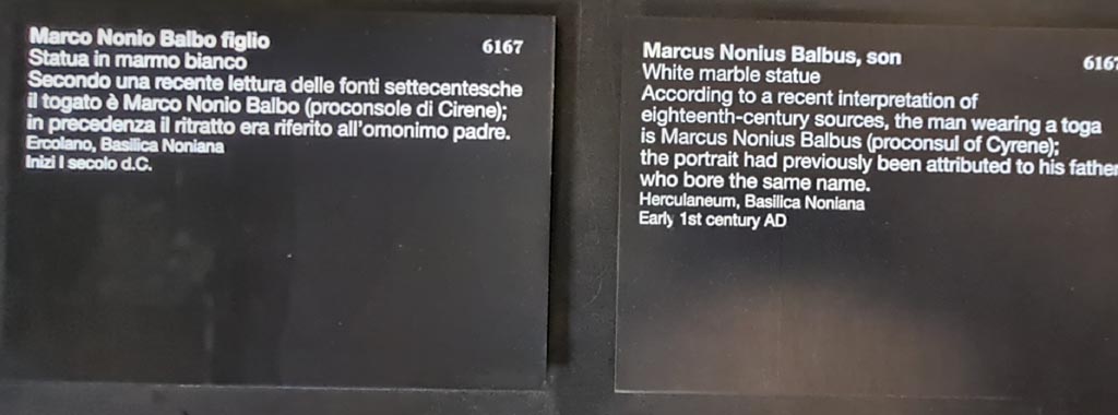 Herculaneum Basilica Noniana. April 2023. Exhibition descriptive card for statue of Marco Nonio Balbo figlio inventory number 6167. 
Photo courtesy of Giuseppe Ciaramella.
