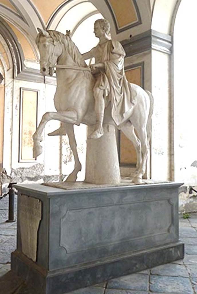 VII.16 Herculaneum. September 2015. Reproduction equestrian statue of the younger M. Nonius Balbus at Palazzo Reale.
This cast was placed here recently as a reminder of where the original stood in the mid eighteenth century.
Now in Naples Archaeological Museum. Inventory number 6104.
A copy of the original inscription plaque is attached to the front. When first found this identified the statues as M. Nonius Balbus.