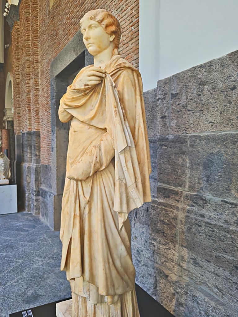 Herculaneum, public area. April 2023. 
Detail of white marble “Piccola Ercolanese” type statue of a young woman.
On display in “Campania Romana” gallery of Naples Archaeological Museum, inv. 6244.
Photo courtesy of Giuseppe Ciaramella.
