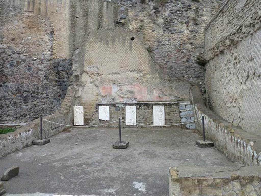 Herculaneum, September 2015. Sacred Area terrace, looking north in the shrine of the Four Gods. The copies of the reliefs are thought to be hanging in their original position, fastened to the front wall of the podium.  The originals, now in Naples Museum, were recently found on the ancient beachfront, no doubt thrown there by the force of the eruption, and show Minerva, Neptune, Mercury and Vulcan.
