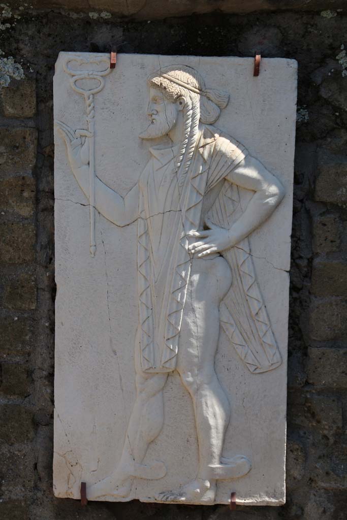 Herculaneum, April 2014. Sacred Area terrace, the shrine of Four Gods. Reproduction relief of Mercury. 
Photo courtesy of Klaus Heese.
