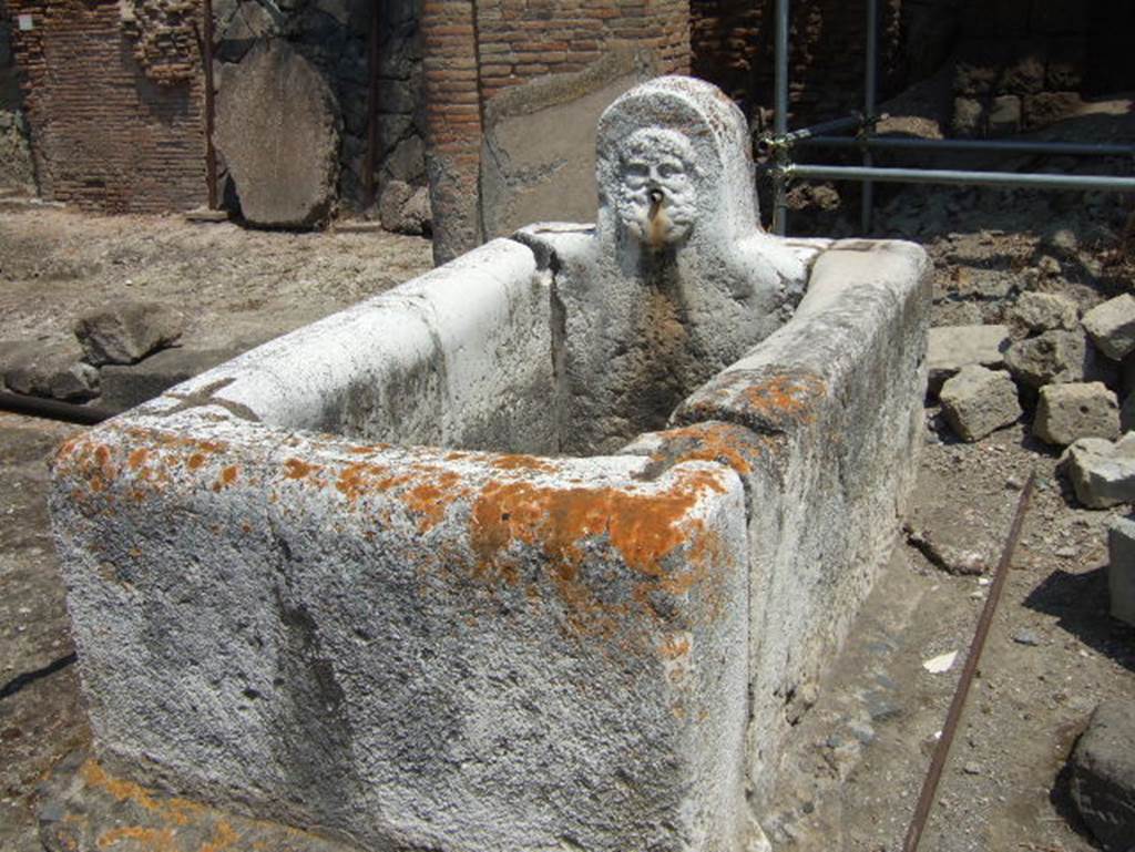 Fountain decorated with head of Hercules at south end of Decumanus Maximus, Herculaneum.  May 2006. Looking east.

