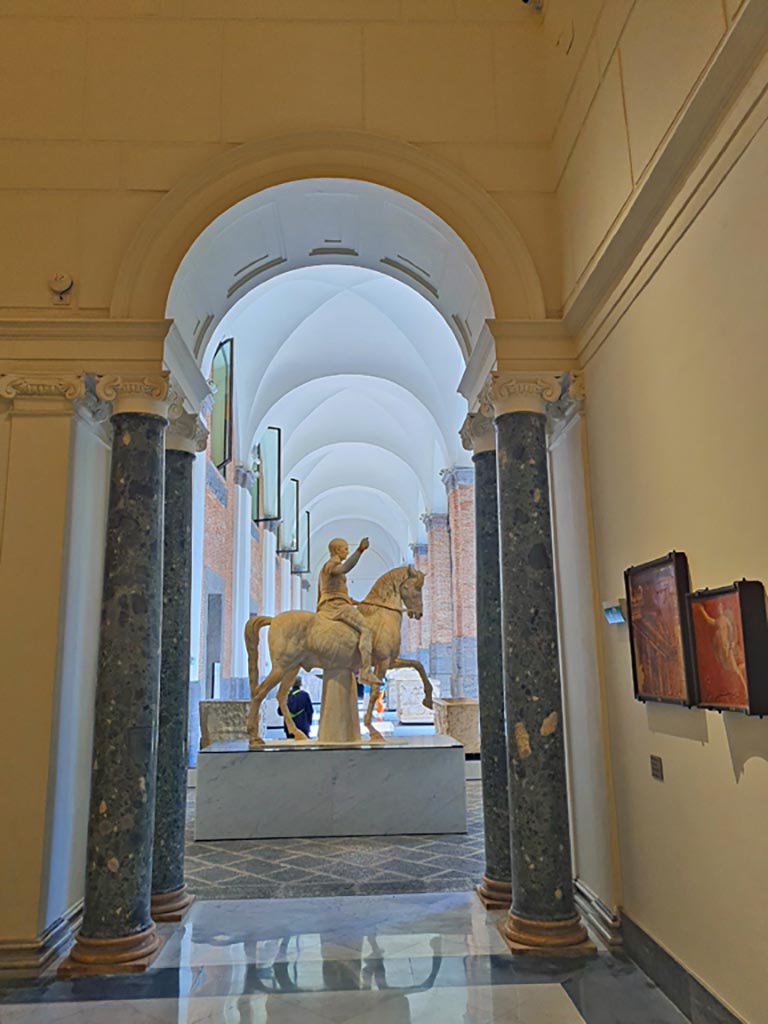 Naples Archaeological Museum, April 2023. 
Looking out from Herculaneum Augusteum gallery display in “Campania Romana” gallery towards statue of Marcus Nonius Balbus.  
Photo courtesy of Giuseppe Ciaramella.
