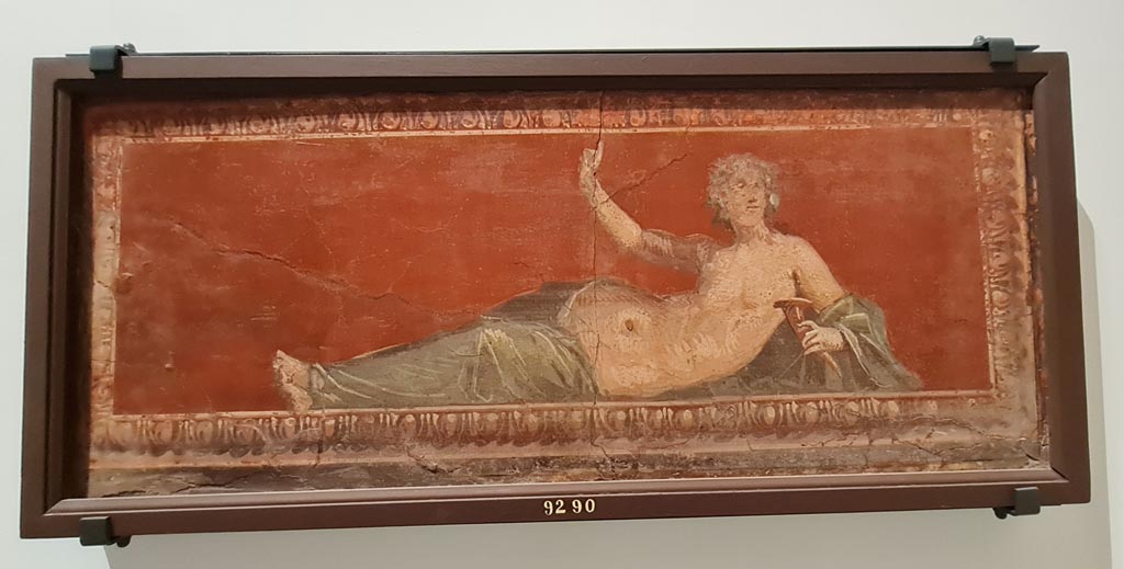 Herculaneum Augusteum. April 2023. Paintings on wall to left of Arch through to display from Theatre. 
Maenad lying down with a rhyton and a cornice with egg and dart decoration - inv. 9290. Photo courtesy of Giuseppe Ciaramella.
