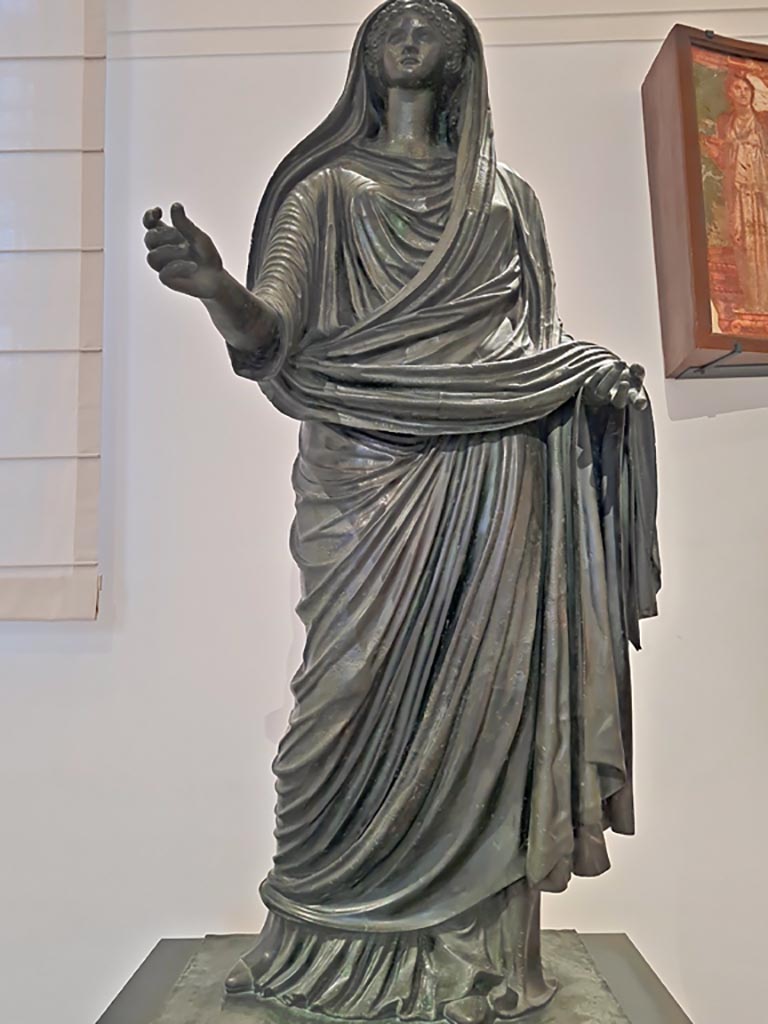 Herculaneum Augusteum. April 2023. 
Detail of bronze statue of Agrippina Minor, inv. 5609.
On display in “Campania Romana” gallery in Naples Archaeological Museum. 
Photo courtesy of Giuseppe Ciaramella.
