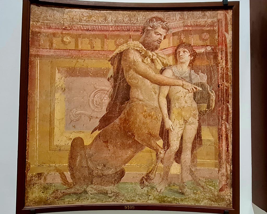 Herculaneum Augusteum. April 2023. 
No.3 on above descriptive card, and below – Achilles and Chiron, inv. 9109. 
On display in “Campania Romana” gallery in Naples Archaeological Museum.  Photo courtesy of Giuseppe Ciaramella.

