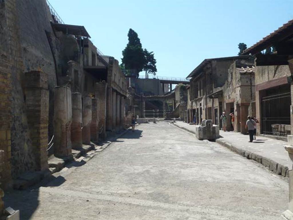 Herculaneum. August 2013. Looking east along Decumanus Maximus, from four-sided arch.  The entrance doorway shown in the photo above, is on the left behind the ropes. Photo courtesy of Buzz Ferebee.

