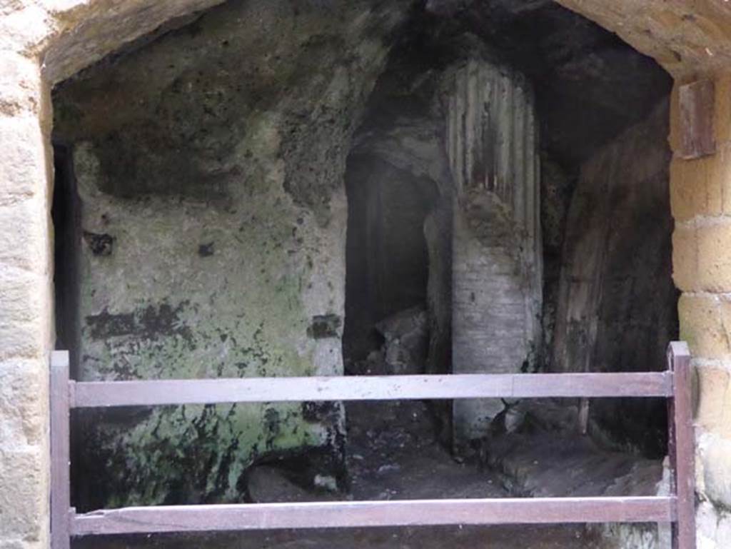 II.2 Herculaneum, October 2014. Looking west through doorway and Bourbon tunnel under Via Mare. Photo courtesy of Michael Binns.
According to Bonucci (April 1828) –
“Da uno di questi portici si passa in altri piu piccioli e piu segreti (Tav. XII, no.3). 
Essi son situati a settentrione per godervi dell’ombra e del fresco nelle ore meridiane. Ivi solevano tenersi le conversazioni verso il tramonto del sole……...
Le pareti vi son decorate da gentili ornamenti. Figurano delle architetture capricciose e sullo stile di M. Ludio (Tav. XII, no.4,4). Il loro fondo e nero, gli scompartimenti ed i frontispizi d’un rosso assai vivo; degli amorini, de’paesetti, delle ghirlande, degli animali chimerici, degli uccelli e de’fiori ravvivano di tratto in tratto questi campi ov’ha delirato l’antica pittura.
Cosi questo portici e questi boschetti davano un aspetto assai poetico all’intiera abitazione e realizzano a’ nostri sguardi una di quelle superbe magioni di cui son piene le antiche pitture e che dovevano essere le immagini di questi magnifici originali.” 
(From one of these porticoes, one passes into another, smaller and more secret, (Tav. XII, no.3). 
This is situated towards the north to give shade and fresh air from the afternoon sun……………….
The walls are decorated with pleasant decorations. There are capricious architectures (Tav. XII, 4,4). The lower walls are black, the upper compartments are a very bright red: some cupids, landscapes, chimeric animals, birds and flowers enliven these walls from side to side where the ancient painting has delighted. So these porticoes and groves gave a very poetic aspect to the whole house, and show to our eyes one of those superb mansions of which the ancient paintings are full of, and which must have been the image of those magnificent originals”)
See Ruggiero, M. (1885). Storia degli scavi di Ercolano ricomposta su’ documenti superstiti. (p.548-9).

