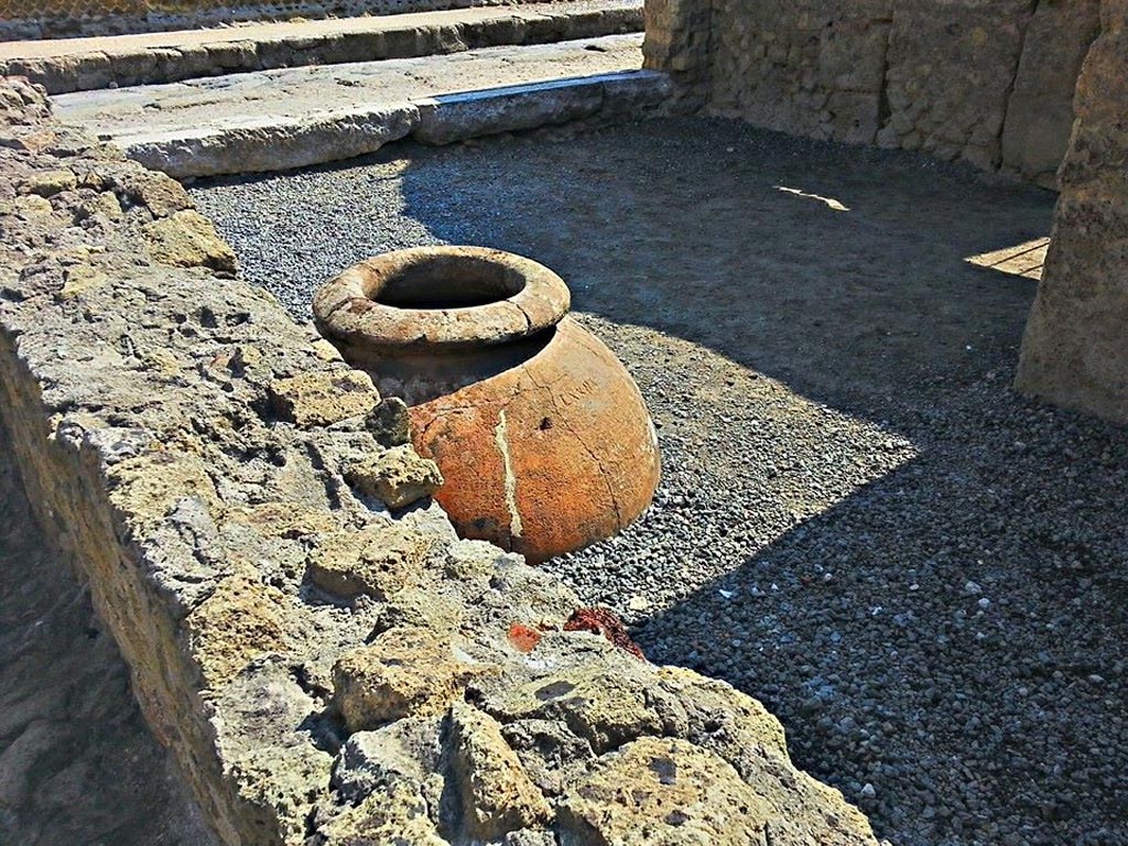 III.6 Herculaneum, photo taken between October 2014 and November 2019. 
Looking north across shop-room with buried dolium towards entrance doorway. Photo courtesy of Giuseppe Ciaramella.
