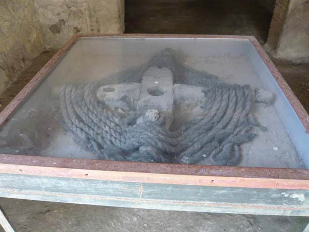 III.15, Herculaneum May 2009. Windlass and rope. Photo courtesy of Buzz Ferebee.
According to Pesando and Guidobaldi, displayed in a showcase is the winch and carbonized rope relevant to the shaft of the well in the courtyard. 
See Pesando, F. and Guidobaldi, M.P. (2006). Pompei, Oplontis, Ercolano, Stabiae. Editori Laterza, (p.326)


