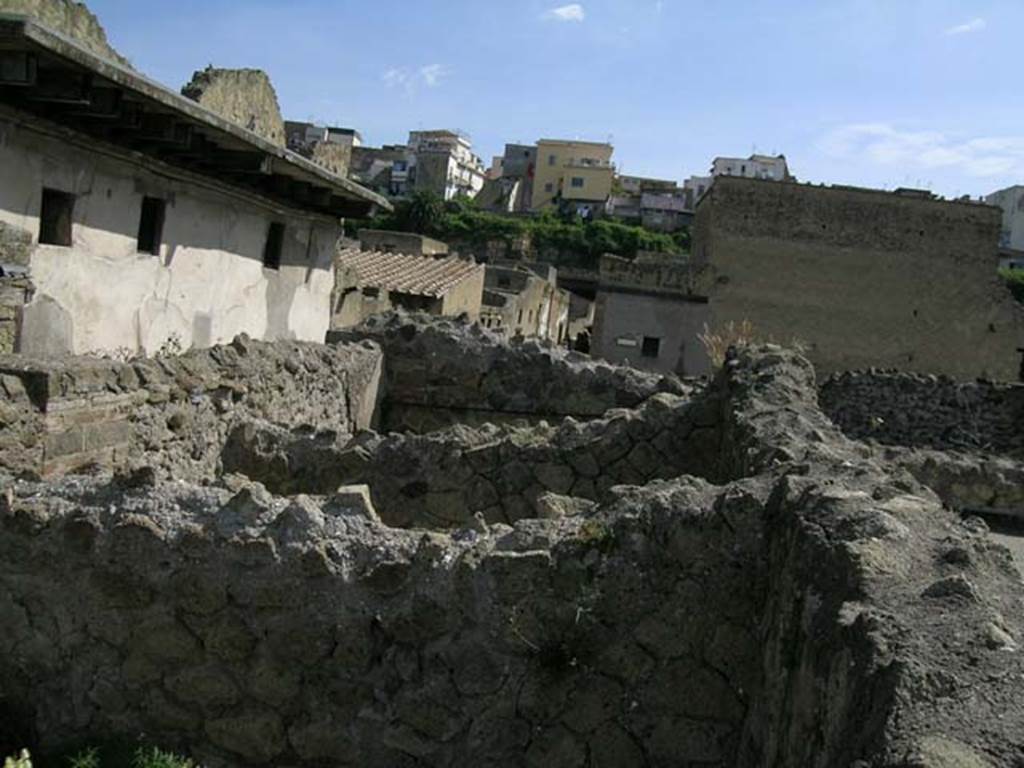 IV.3/4, Herculaneum, May 2005. 
Upper floor, looking north towards III.11 (white building, on left), and fullonica at IV.5/6/7, centre. 
Photo courtesy of Nicolas Monteix.
According to Monteix, on the west side of the upper floor were three rectangular tubs/basins used as an attic granary.
Found: 30th November 1928, at the back of the wall was found a rectangular tub/basin 2.09m long, by 1.54m wide, with a depth of 0.86m.
In it was a deposit of cereals, grain, inventory no.378.
Found: 8th January 1929, the two tubs placed to the north of the already described on 30th November have been excavated. 
The second was 2.10m long, 1.50m wide, and 0.85 deep. The walls were completely covered with plaster. The base was of cocciopesto and reasonably conserved. No objects were found.
The third was 2.10m long, 1.80m wide, and 0.85m deep. No objects……
See Monteix, N. 2008. La conservation des denrées dans l’espace domestique à Pompéi et Herculanum, MEFRA 120-1, p. 131.
