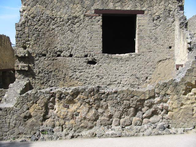 IV.11, Herculaneum, May 2003. Looking towards exterior wall on south side of Decumanus Inferiore, on east side of entrance doorway, on right.  The large window would have given light to the large triclinium, from a corridor with latrine. Photo courtesy of Nicolas Monteix.
