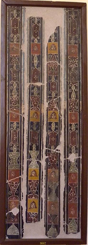 IV.21 Herculaneum, either Cryptoporticus 31 (west side) or 29 (east side).
Found 6th August 1748.
Two panels divided into 4 vertical faces showing painted figures and masks. 
Now in Naples Archaeological Museum. Inventory number 9687.

Maiuri wrote that the ample quadriporticus (Cryptoporticus) having lost the architectonic element of the columns, now assumed the more convenient form of a corridor with windows, whilst it preserved the wall decorations and that of the flooring. The charming little pictures that still survive inserted into the panels on the walls, with scenes of Cupids Playing, belong to a longer series of pictures which were detached during the preceding excavations and are now preserved in the Naples Museum.
See Maiuri, Amedeo, (1977). Herculaneum. 7th English ed, of Guide books to the Museums Galleries and Monuments of Italy, No.53, (p.61-63).
According to Deiss, In front of the dining room and paralleling the long sides of the rectangle, runs a covered gallery without columns. The floor is black and white mosaic. Along the length of the corridor, panels show cupids at play, games like Blindmans bluff, and Hide and Seek. Most of the painted panels were removed to Naples Archaeological Museum.
See Deiss, J.J. (1968). Herculaneum, a city returns to the sun. London, The History Book Club, (p.41).
