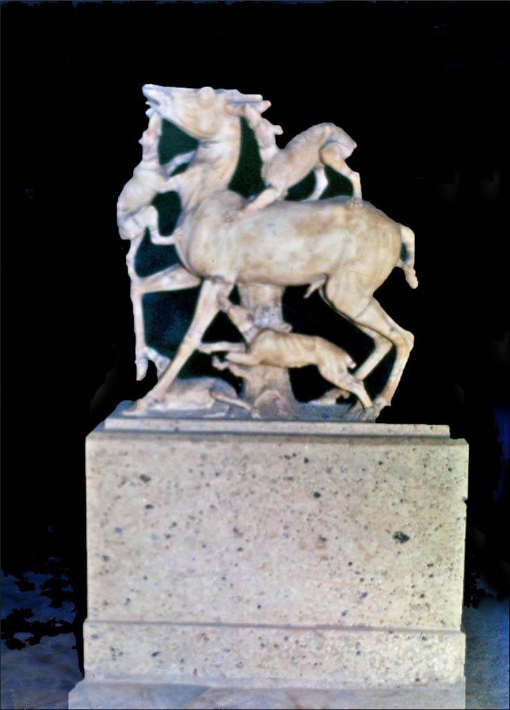 IV.21, Herculaneum. 1978. 
Statue of deer being attacked by hounds, on display in a room of the house.  Photo by Stanley A. Jashemski.  
Source: The Wilhelmina and Stanley A. Jashemski archive in the University of Maryland Library, Special Collections (See collection page) and made available under the Creative Commons Attribution-Non-Commercial License v.4. See Licence and use details.
J78f0522
