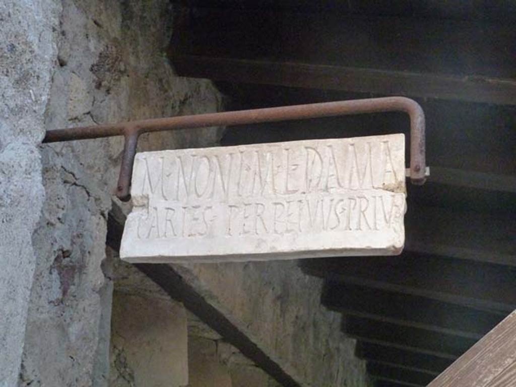 V. 4, Herculaneum, September 2015. Marble plaque marking the property boundary of M. NONI M. L. DAMA.
This north side of this boundary marker would be the property at V.5, Casa del Mobilio carbonizzato or House of the Wooden Furniture.  According to Wallace-Hadrill, a reconstructed marble plaque has been hung from an iron fixing on the façade of these properties at the boundary point.  On one side JULIA, on the other M(arcus) NONIUS M(arci) l(ibertus) DAMA……
We cannot reconstruct what it was that made Nonius Dama and Julia argue over their boundary, but at least it reveals the identity of the owners on the two sides, a freedman belonging to the biggest family in town, and a woman whose imperial name implies that she too was from a family of imperial freedmen. Who owned which side (and if the plaque has been put back in the right position), we cannot tell.
See Wallace-Hadrill, A. (2011). Herculaneum, Past and Future. London, Frances Lincoln Ltd., (p.215).

