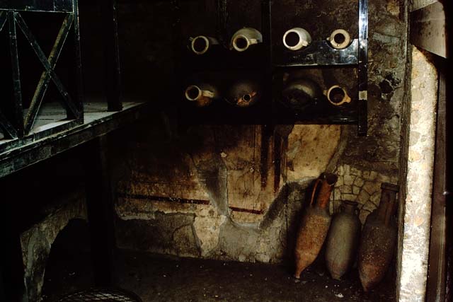 Ins. V, 6, Herculaneum, 1964. Amphora rack against south wall of shop ...