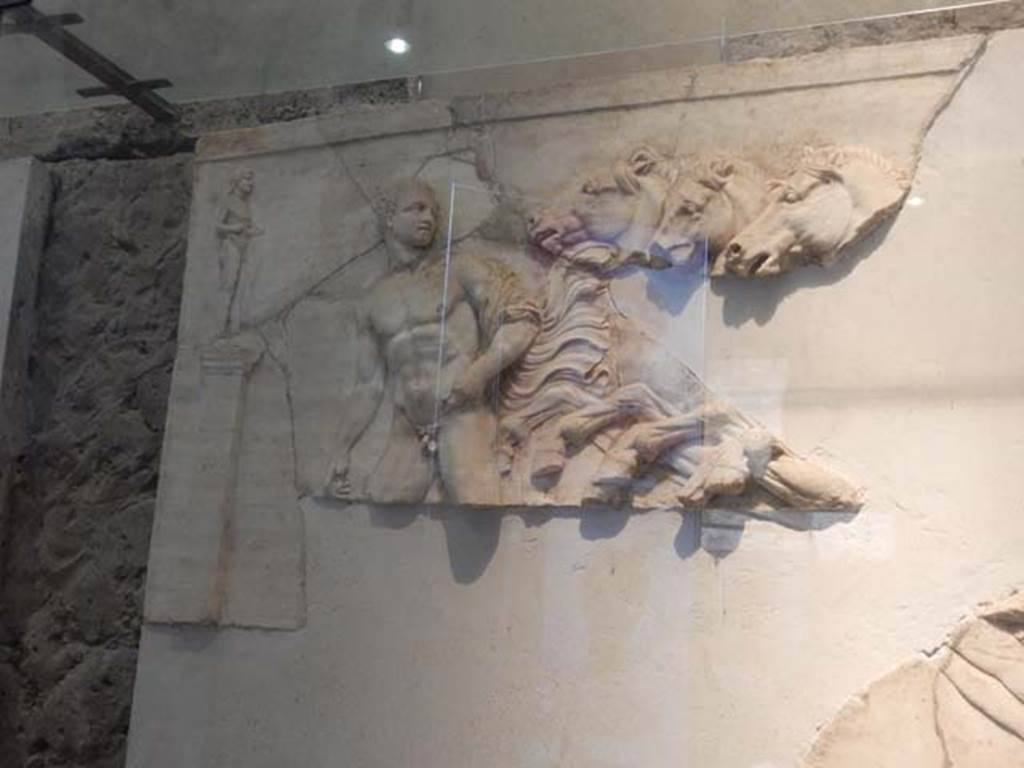 V.8 Herculaneum. May 2018. Room 7, marble relief of Tramonto and carriage, hanging from south wall, but actually found in fragments in Cardo V.  
Photo courtesy of Buzz Ferebee.
