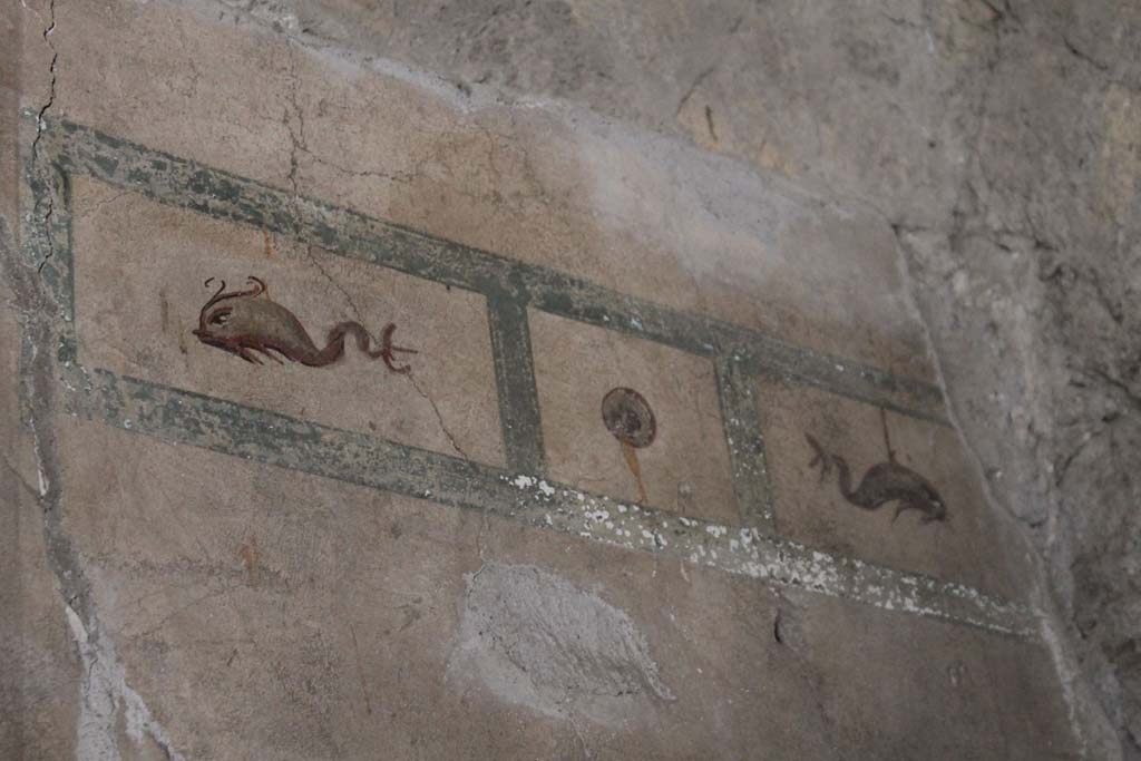 V.8 Herculaneum. May 2018. Room 1, north wall of entrance hall, with detail of painted decoration from east end of wall.
Photo courtesy of Buzz Ferebee.
