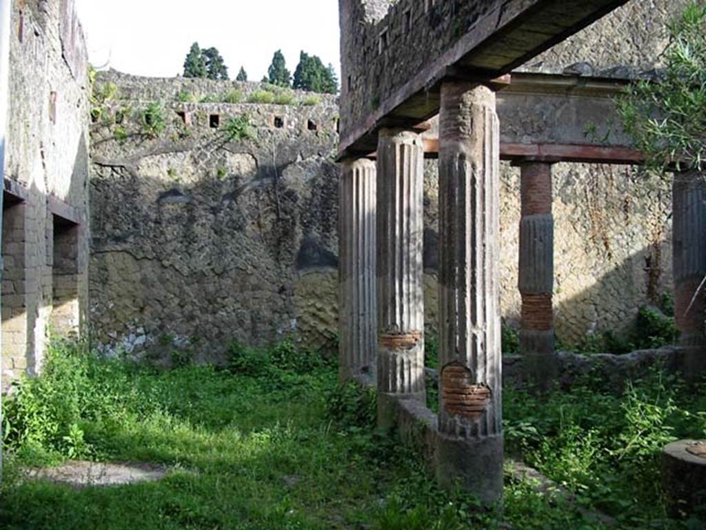 V.15, Herculaneum. May 2003. Looking east across north portico, with window and doorway to triclinium, on left.
Note the support holes for the upper floor beams. Photo courtesy of Nicolas Monteix.
