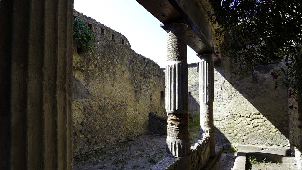 V.15 Herculaneum. August 2021. 
Looking south across east portico towards kitchen area, with niche in both the east and south walls. Photo courtesy of Robert Hanson.
