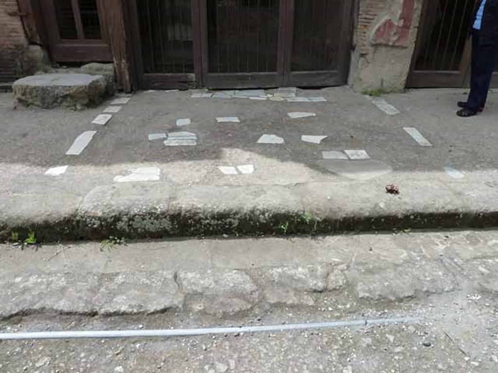 V.17/18, Herculaneum. May 2004. Marble inserted into the pavement outside the doorways.
Photo courtesy of Nicolas Monteix.
