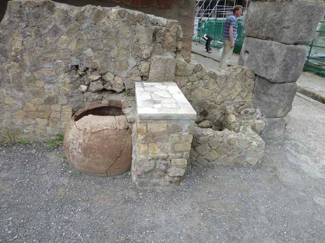 V, 21, Herculaneum, May 2010. West wall of shop-room with counter.