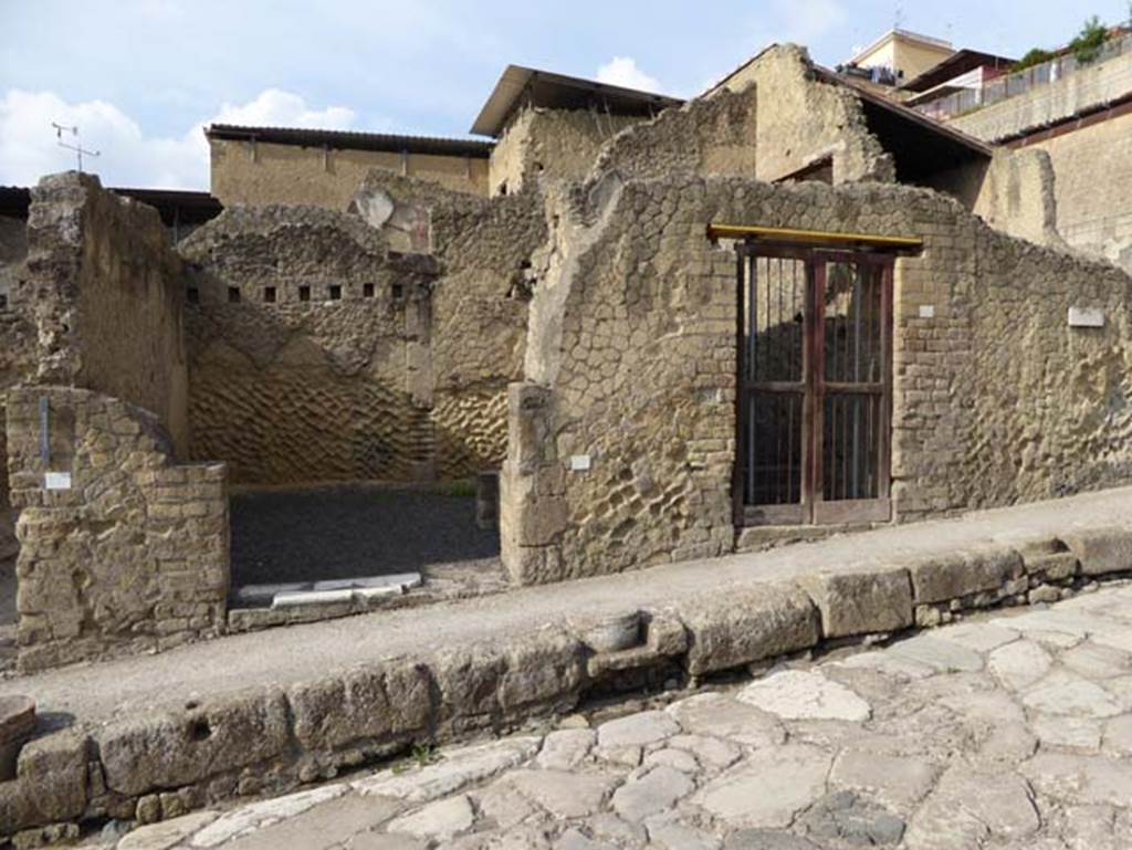 V.22, on right, Herculaneum, October 2014. Entrance doorways on west side of Cardo V Superiore.  On the left is the entrance doorway to shop at V.23. Photo courtesy of Michael Binns.
