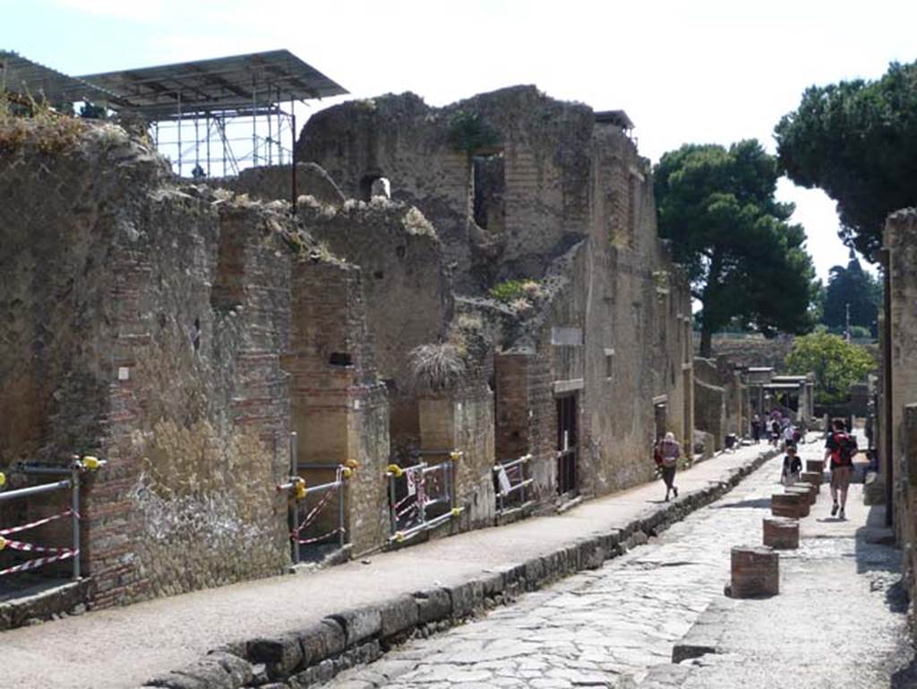 Ins. Orientalis II. on left, Ins. V, on right, Herculaneum. May 2009. Looking south on Cardo V Superiore.  The remains of the brick columns along the edge of the roadway, on right, would have supported a small portico. Photo courtesy of Buzz Ferebee.
According to Maiuri, outside the doorway of V,30 was a little portico along the roadway, and by a stretch of better pavement adorned with marble.
See Maiuri, Amedeo, (1977). Herculaneum. 7th English ed, of Guide books to the Museums Galleries and Monuments of Italy, No.53 (p.50-51).

