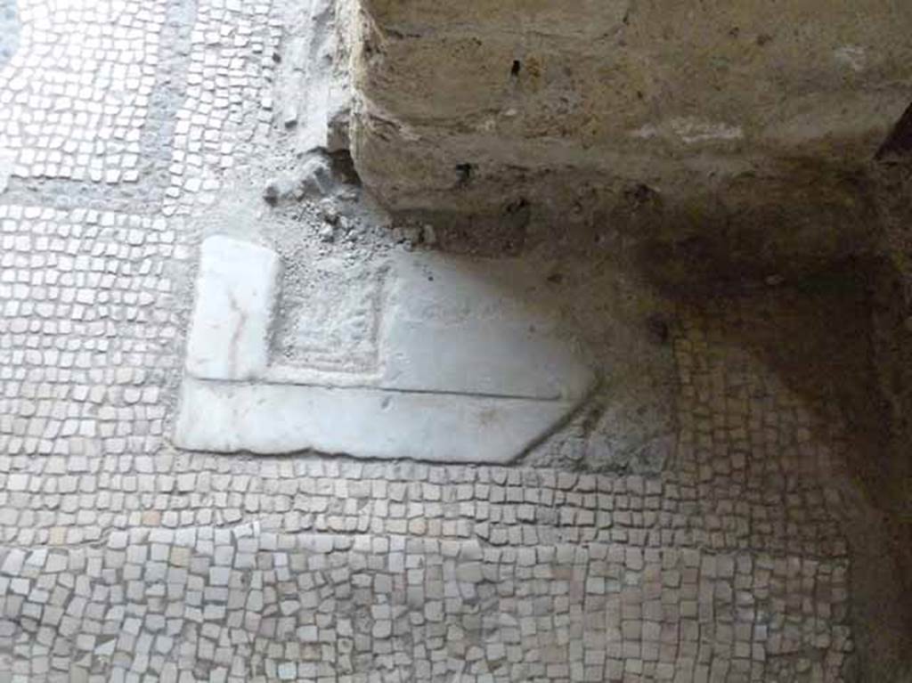 VI.1/7. May 2010. Marble rectangular groove for the hinge/pivot of the door, and mosaic floor of tepidarium, leading into caldarium.

