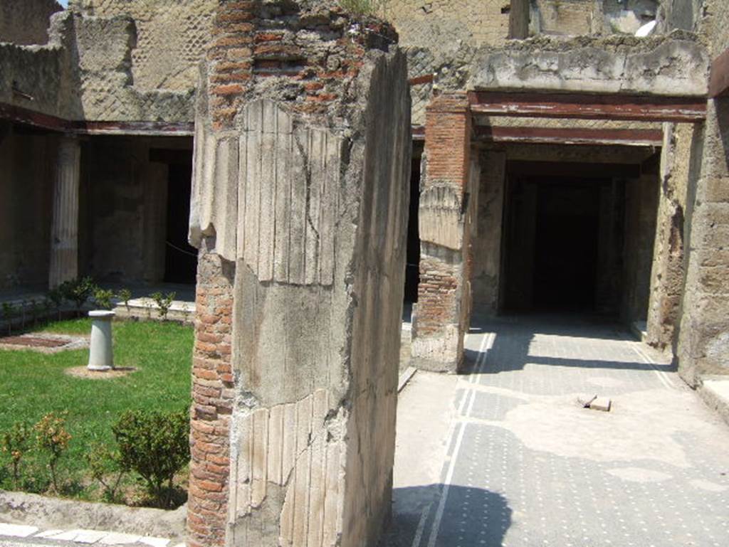 VI.13, Herculaneum, May 2006. Peristyle 13, looking west across north side of peristyle.
On the left is the large doorway to the large oecus, the Salon Nero, from which the house is named.


